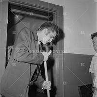 Photograph of Elvis Presley sweeping floor