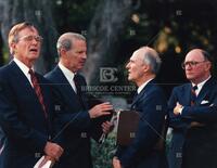 President George H. W. Bush reacts to news from Secretary of State James Baker