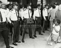 [Child protestor with police officers]