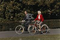 [President and First Lady Bush riding bicycles]