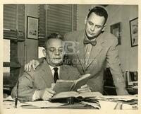 Maury Maverick, Sr., (seated), examines a book with son Maury Maverick, Jr.