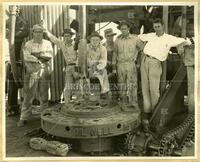 [Six men posing with oil drill]