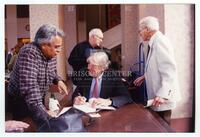 University of Texas at El Paso visit, book signing event, Bernard Rapoport with three unidentified individuals, signing a copy of "Being Rapoport"