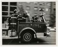 Father Capistran riding a fire truck