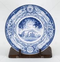 Photograph of a blue and white plate with a picture of Gregory Gymnasium on it.