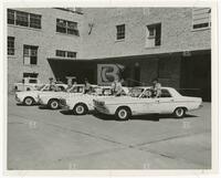 Photograph of UT Traffic and Security Officers standing by their vehicles