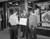 Man with sign outside Rexall Drugs store