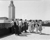 Group of students on campus with Main Building in background