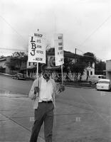 Man holding two signs in protest during Civil Rights Demonstration