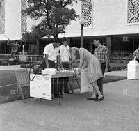 Photograph of students at Western Union Telegram booth on mall outside building