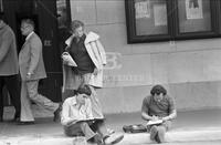 Photograph of architecture students drawing with people looking at them