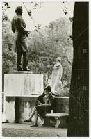 Photograph of student studying by the Jefferson Davis sculpture on campus