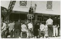 Photograph of sculpture being raised in front of campus building