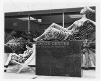 Photograph of student sitting by The Three Muses sculpture by Charles Umlauf, undated