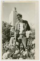 Photograph of two UT students in the flowers with the Tower in the background