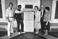 Four representative members of the Centennial Class of 1983 pose with President Peter T. Flawn