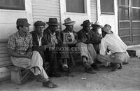 Men gather at an informal hiring corner.