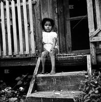A child who lives in a slum corral.