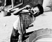 Boy drinking from outdoor hydrant