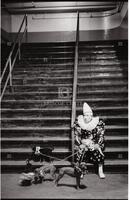 Photograph of a clown sitting on a set of stairs