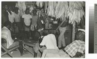 Photograph of John Walsh playing cards with locals in Suriname, 1964
