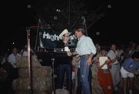 Photograph of Jim Hightower shaking hands with Robert Redford at a campaign event, 1990