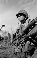 Photograph of a U.S. Marine with two rifles, 1967