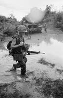 Photograph of a U.S. Marine with a tank in the background