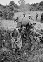 Photograph of a U.S. Marine wrapping the body of a dead soldier, 1967