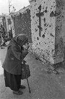 Photograph of a person in front of a destroyed church