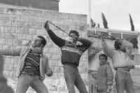 Photograph of Palestinian youths aiming slingshots