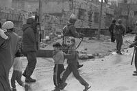 Photograph of children walking among Israeli forces