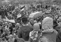 Photograph of a crowd carrying a casket