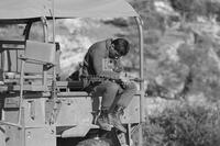 Photograph of an Israeli soldier sitting on a vehicle