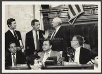 Black and white photograph of Jack Brooks speaking with William S. Cohen and others during the Iran-Contra hearings, 1987