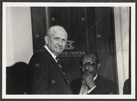 Black and white photograph of Jack Brooks and Representative Louis Stokes looking into the camera during the Iran-Contra hearings, 1987