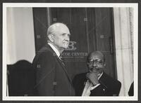 Black and white photograph of Jack Brooks speaking with Representative Louis Stokes during the Iran-Contra hearings, 1987