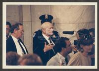 Color photograph of Jack Brooks speaking with press during the Iran-Contra trials, 1987