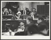 Black and white photograph of Jack Brooks shading his eyes and facing the camera during the Iran-Contra trials, 1987