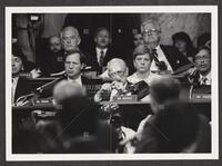 Black and white photograph of Jack Brooks, cigar in mouth, looking into the camera and thinking during the Iran-Contra trials, July 14, 1987