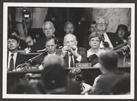 Black and white photograph of Jack Brooks taking a smoke of his cigar during the Iran-Contra trials, July 14, 1987