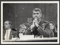Black and white photograph of Lt. Col. Oliver North resting his head on his hands during the Iran-Contra trials, July 14, 1987