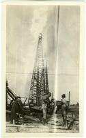 [Men working in front of an oil well]