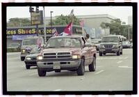 Negatives of a truck carrying a large Cuban flag in the flatbed with a group of people sat in the back, April 7, 2000
