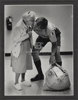 And One For You; Arlington Memorial Hospital's 90-year-old volunteer, "Grannie" Elder stops to kiss one of her favorite "hunks" who comes to visit her in the hospital mail and flower room as she goes about duties. She is renowned throughout the hospital f