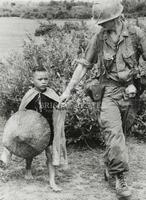U.S. Marine comforting Vietnamese boy