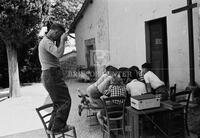 Russell Lee on chair with camera, San Donato, Italy, 1960