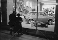 Couple looking at car show room, Turin, Italy, 1960