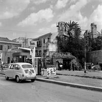 Gas station with car and farm cart, Sicily, 1960