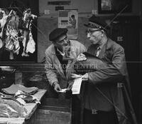 Men bargaining at meat market, Sicily, 1960
